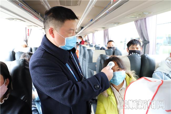 工作人员正在为返岗群众进行体温检测.JPG