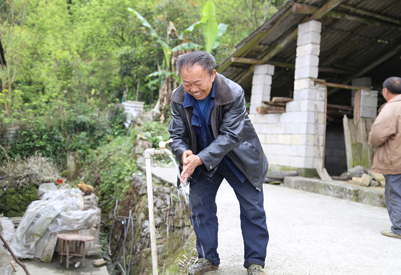 大营镇大营村鼠场坡组村民韦堂国打开房前水龙头洗手.jpg