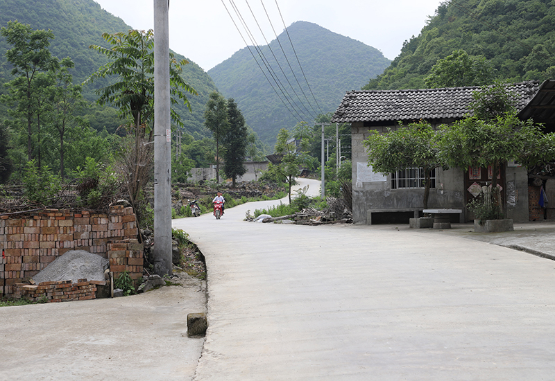 村民骑着摩托车，沿着通组路出行.jpg