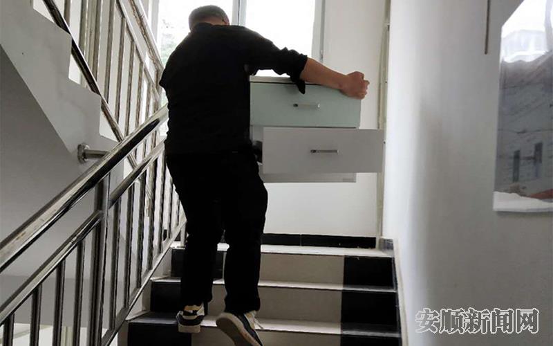 安置点网格员正在帮搬迁群众搬家具.jpg